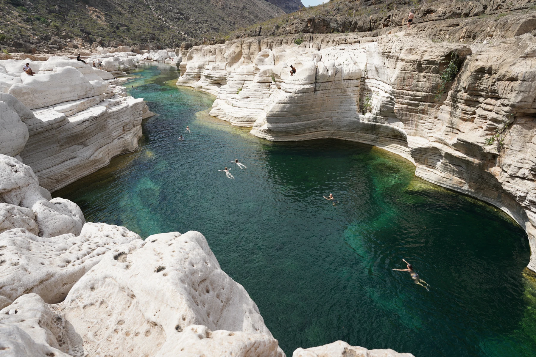 Rocky canyon walls and clear pools at Wadi Kalisan