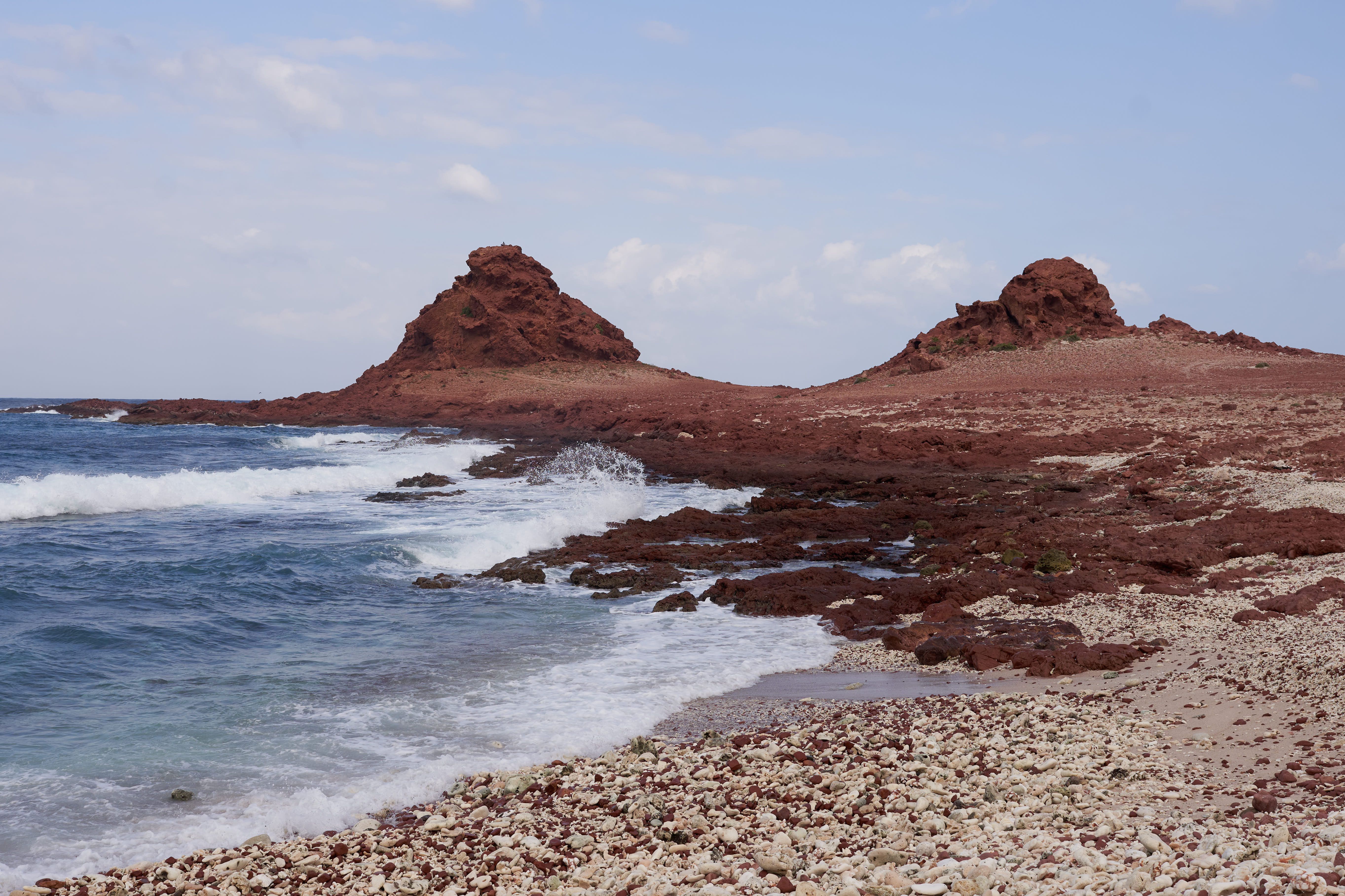 Red rock and surf along the Socotra coast